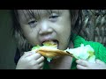 A 3-year-old girl harvests giant snails to sell at the market