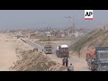 Trucks carrying badly needed aid for Gaza roll across newly built US pier