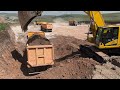 Komatsu Excavator loading double sided truck.