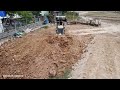 Komatsu D20P dozer pouring soil delete pond to build foundation house with dump trucks unloading