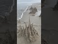 Sandcastle destroyed by a wave