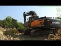 Hyundai HX300S Excavator Loading Dump Trucks On The New Road Construction