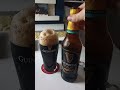 Pouring a bottle of Guinness Foreign Extra Stout into a Guinness pint glass