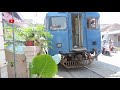 A Train Stops in front of a house because a Woman parks motorcycle carelessly