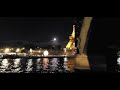 Eiffel Tower at night with moon and Olympics countdown clock - from Seine river cruise