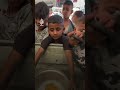 طفل فلسطيني ينتظر بإنائه الفارغ للحصول على طعام شحيح في غزة