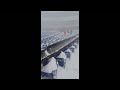 Fan slides down snow-covered stairs inside the Buffalo Bills NFL stadium