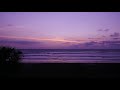 A dramatic sunset time lapse when the clouds are coming on shore. Amazing transition of colors.